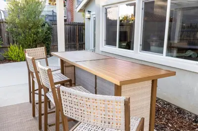 a wooden table and chairs on a patio at Sumptuous Coastal Hideaway in Oceanside
