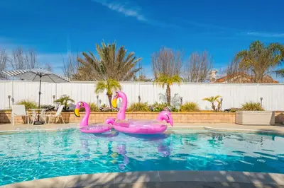 three pink flamingos are in a swimming pool at Luxury poolside « Villa Descanso » with heated pool and Spa! Close to San Diego/ Legoland in Oceanside