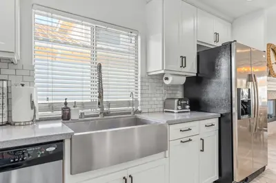 a kitchen with a sink and a stainless steel refrigerator at Luxury poolside « Villa Descanso » with heated pool and Spa! Close to San Diego/ Legoland in Oceanside