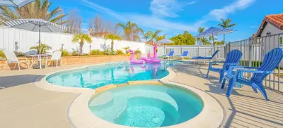 a swimming pool with blue chairs and a table and chairs at Luxury poolside « Villa Descanso » with heated pool and Spa! Close to San Diego/ Legoland in Oceanside