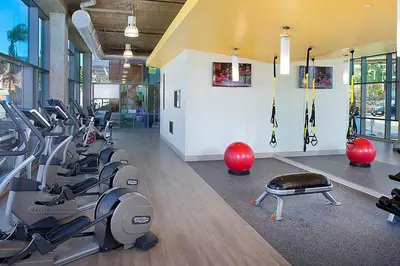 a gym with treadmills and exercise bikes in a room at Little Italy studio w gym pool nr light rail SAN-6 in San Diego