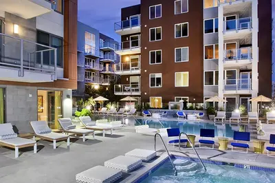 a patio with a swimming pool and chairs and a building at Little Italy studio w gym pool nr light rail SAN-6 in San Diego