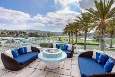 a patio with chairs and a table and palm trees at Luxury Villa at Omni La Costa Resort & Spa in Carlsbad