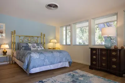 a bedroom with a bed and a dresser and windows at Poolside Splendor! Spacious De Anza Golf Club Home in Borrego Springs