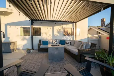 a patio with a couch and a table and chairs at 4Bd, Family Friendly, Fun Yard, Close to Beaches! in Oceanside