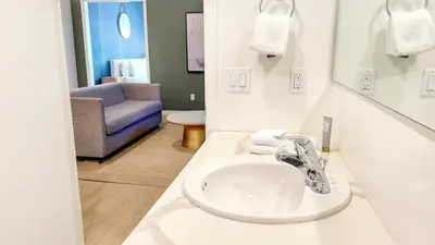 a bathroom with a sink and a blue chair at Ambient Oasis in the Heart of San Diego in San Diego