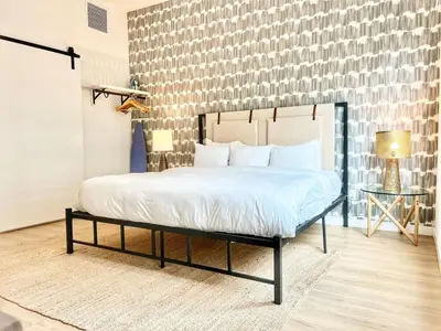 a bedroom with a large bed with white sheets at Boutique Suite in Downtown San Diego in San Diego