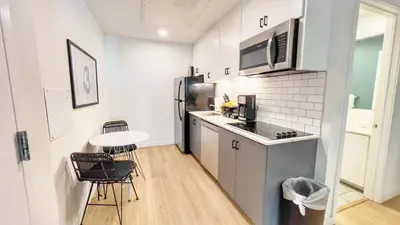 a kitchen with a refrigerator and a table and chairs at Boutique Suite in Downtown San Diego in San Diego