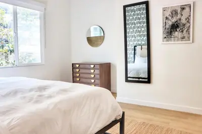 a bedroom with a bed and a dresser and a mirror at Boutique Suite in Downtown San Diego in San Diego