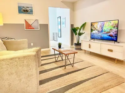 a living room with a couch and a tv at Boutique Suite in Downtown San Diego in San Diego