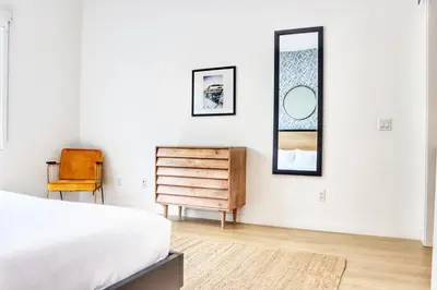 a bedroom with a bed and a dresser and a mirror at Executive Escape in Downtown San Diego in San Diego