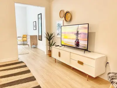 a living room with a flat screen tv on a dresser at Executive Escape in Downtown San Diego in San Diego