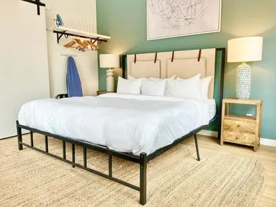 a bedroom with a large bed with white sheets at Grand Downtown San Diego Apartment in San Diego