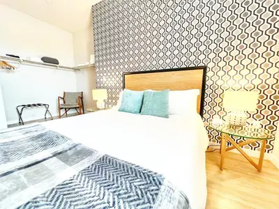 a bedroom with a large white bed and a table at The Leo - Unit 602 in San Diego
