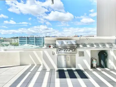 a grill on a balcony with a view of a building at The Leo - Unit 602 in San Diego