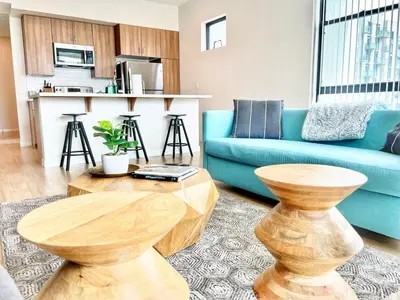 a living room with a blue couch and a table at 3 Bedroom Penthouse in Downtown! in San Diego
