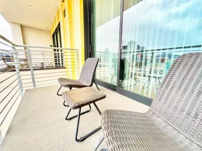 two chairs sitting on the balcony of a building at The Leo - One Bedroom Apartment w Private Balcony in San Diego