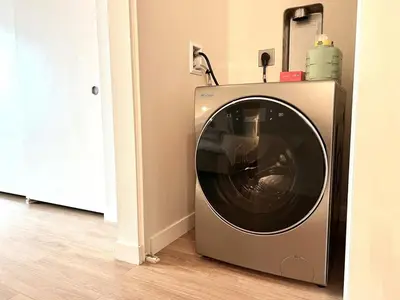a washing machine is sitting in a room at The Leo - One Bedroom Apartment w Private Balcony in San Diego