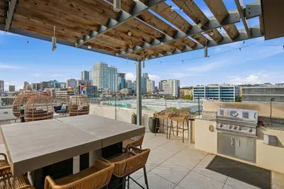 an outdoor patio with a table and a view of the city at The Leo - One Bedroom Apartment w Private Balcony in San Diego