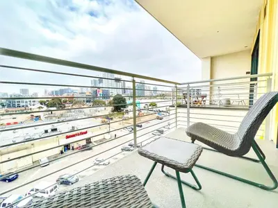 a balcony with a chair and a view of a city at The Leo - One Bedroom Apartment w Private Balcony in San Diego