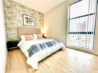 a bedroom with a bed and a large window at One Bedroom Apartment wBalcony and City Views! in San Diego