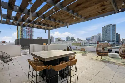 a patio with a table and chairs on a roof at One Bedroom Apartment wBalcony and City Views! in San Diego