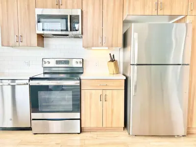 a kitchen with stainless steel appliances and wooden cabinets at One Bedroom Apartment wBalcony and City Views! in San Diego