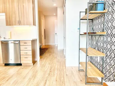 a kitchen with wooden floors and a staircase in a room at Skyline Flat Facing Downtown San Diego in San Diego
