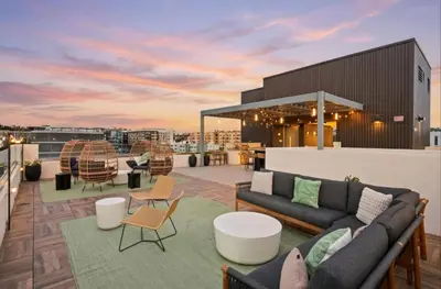 a rooftop patio with couches and tables on a building at Skyline Flat Facing Downtown San Diego in San Diego