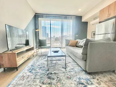 a living room with a couch and a tv at Hidden Gem Apartment in Downtown in San Diego