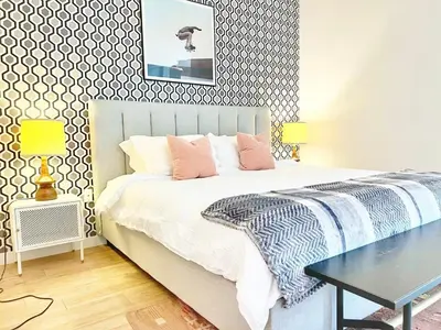 a bedroom with a bed with pink pillows and a table at Sunset Stay in Downtown San Diego in San Diego