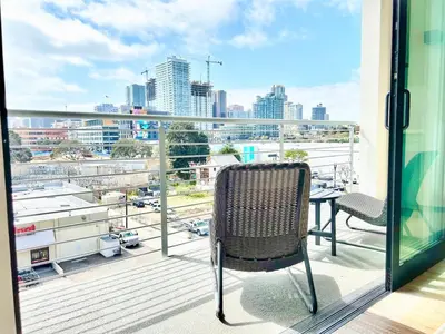 a chair on a balcony with a view of a city at Beautiful One Bedroom Apartment With View of City in San Diego