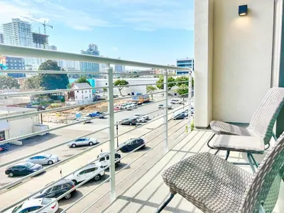 a balcony with chairs and a view of a highway at City View Apartment in Downtown in San Diego