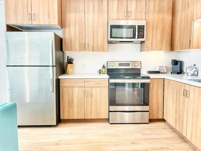 a kitchen with stainless steel appliances and wooden cabinets at City View Apartment in Downtown in San Diego