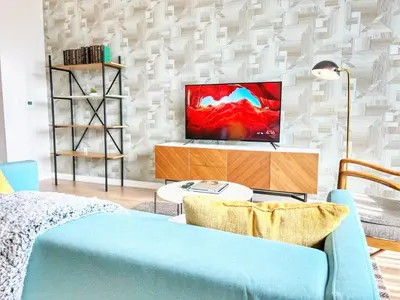 a living room with a tv and a blue couch at City View Apartment in Downtown in San Diego