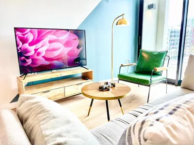 a living room with a couch and a flat screen tv at City View Apartment in Downtown! in San Diego