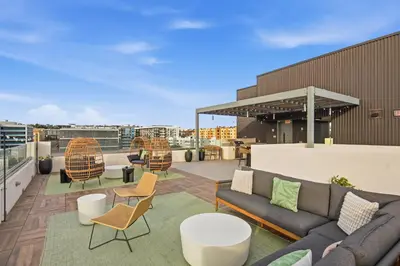 a rooftop patio with couches and tables and chairs at City View Apartment in Downtown! in San Diego