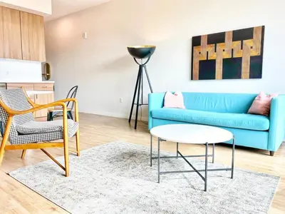 a living room with a blue couch and chairs at San Diego Skyline - Downtown Apartment in San Diego