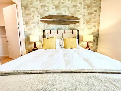 a bedroom with a large white bed with two lamps at San Diego Skyline - Downtown Apartment in San Diego