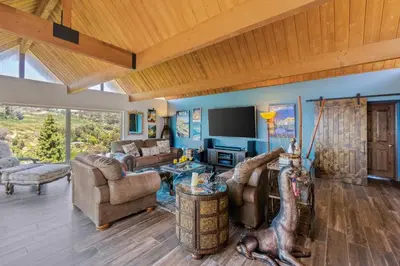 a living room with blue walls and wooden ceilings at Casa Real | House in La Jolla in San Diego