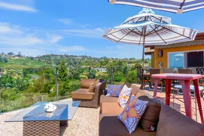 a patio with couches and a table and an umbrella at Casa Real | House in La Jolla in San Diego