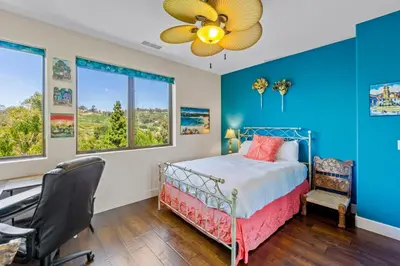 a bedroom with blue walls and a bed with a fan at Casa Real | House in La Jolla in San Diego