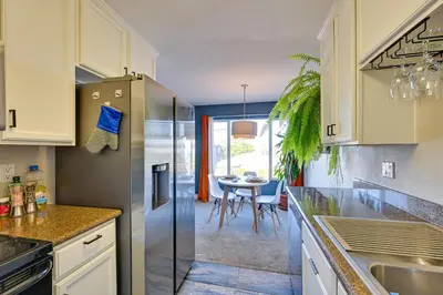 a kitchen with a stainless steel refrigerator and a table at Quiet San Diego Condo with Balcony, Pool and Hot Tub! in San Diego