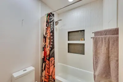 a bathroom with a shower curtain and a toilet at Quiet San Diego Condo with Balcony, Pool and Hot Tub! in San Diego