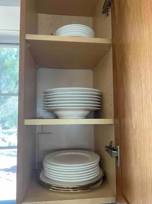 a cabinet filled with plates and bowls in a kitchen at The most breathtaking Lake and Mountain View in Fallbrook