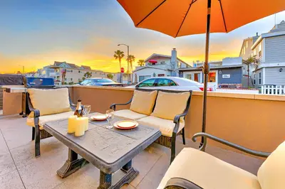 a table and chairs on a balcony with an umbrella at Newport Beach Simplicity III in Newport Beach