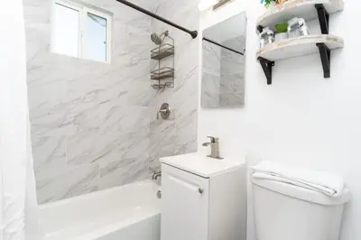 a white bathroom with a toilet and a sink at Nautical Point Loma Getaway - 7 mins to airport in San Diego