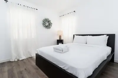 a white bedroom with a large bed with white pillows at Nautical Point Loma Getaway - 7 mins to airport in San Diego