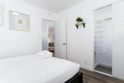 a white bedroom with a bed and a mirror at Nautical Point Loma Getaway - 7 mins to airport in San Diego