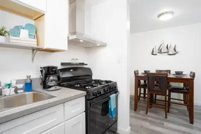 a kitchen with a stove and a sink and a table at Seaside Point Loma Home with Outdoor Patio in San Diego